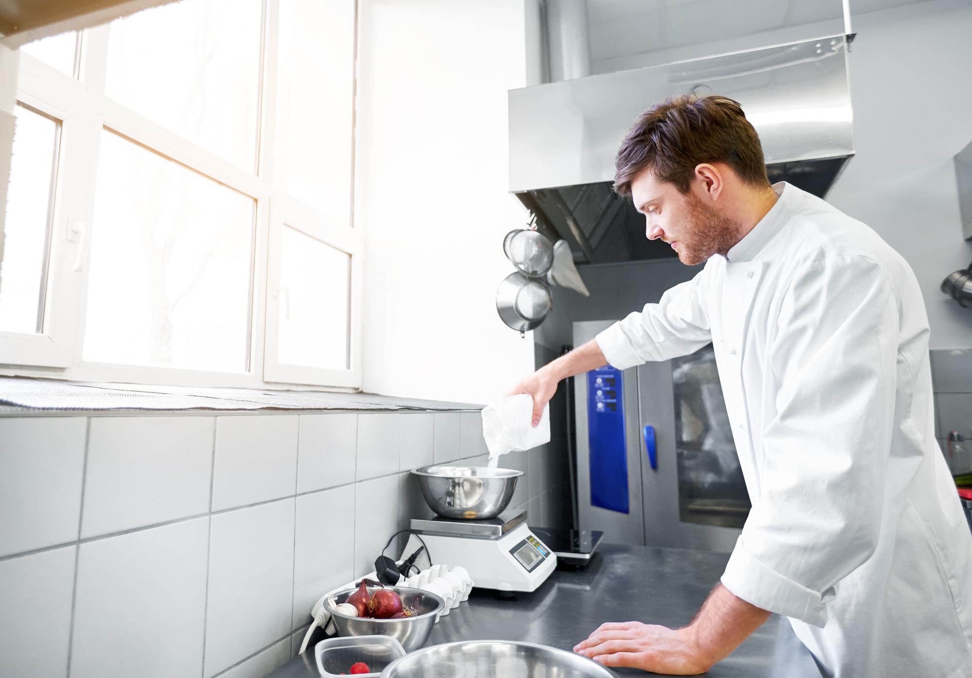 Chef adjusting temperature probe in a compact lab-kitchen